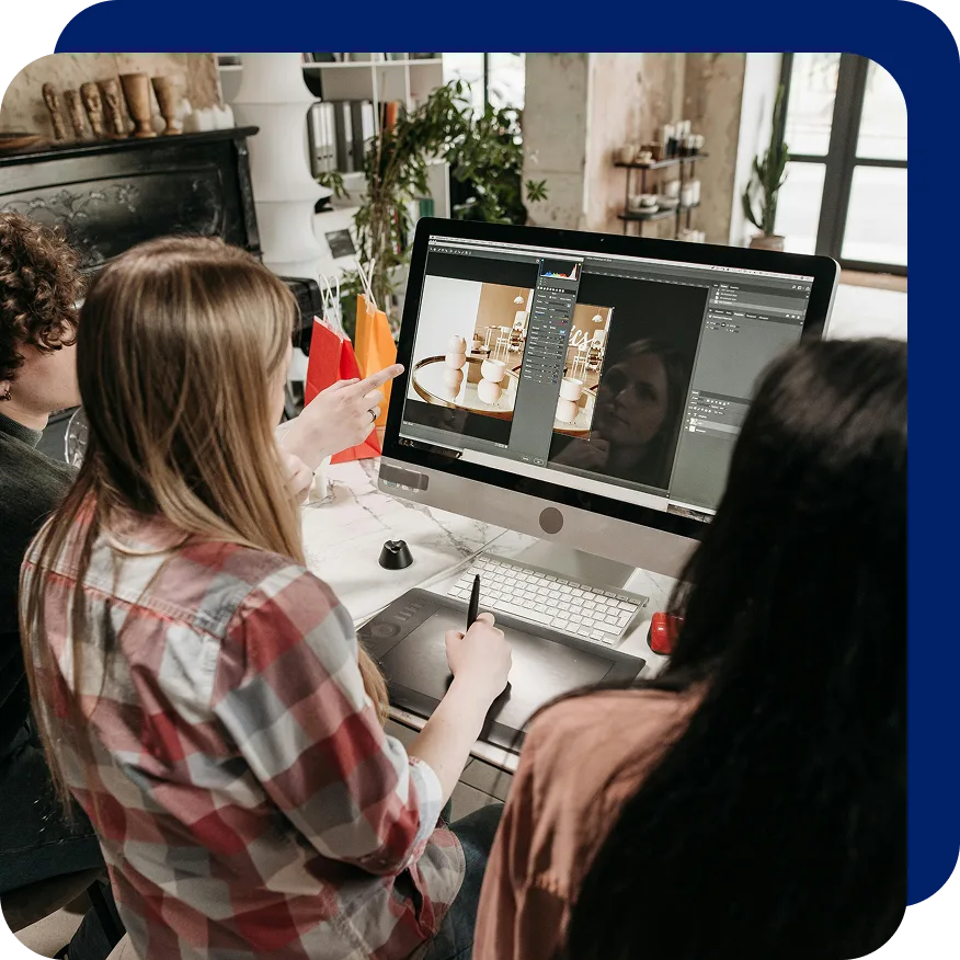 Group of professionals collaborating on digital content at a desktop computer, editing a product photo using design software